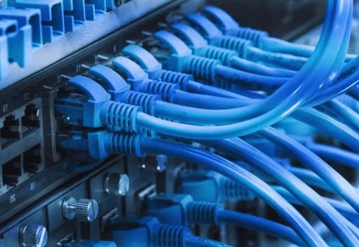 Patch cords azules conectados a un switch en un rack de comunicaciones
