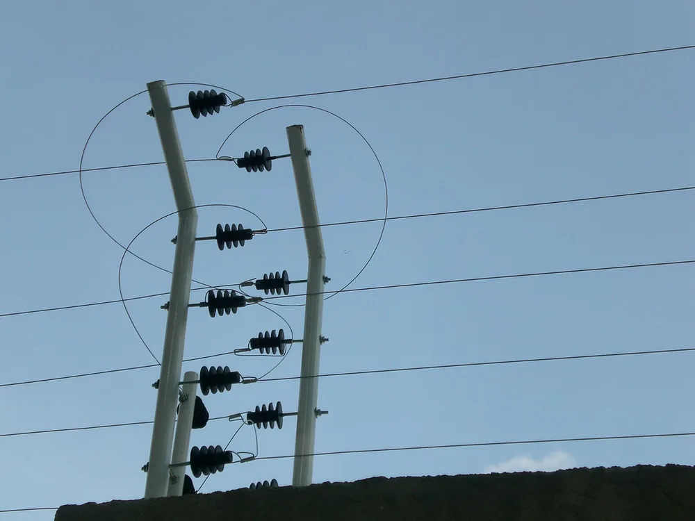 Cerco eléctrico con aisladores negros instalado sobre un muro perimetral